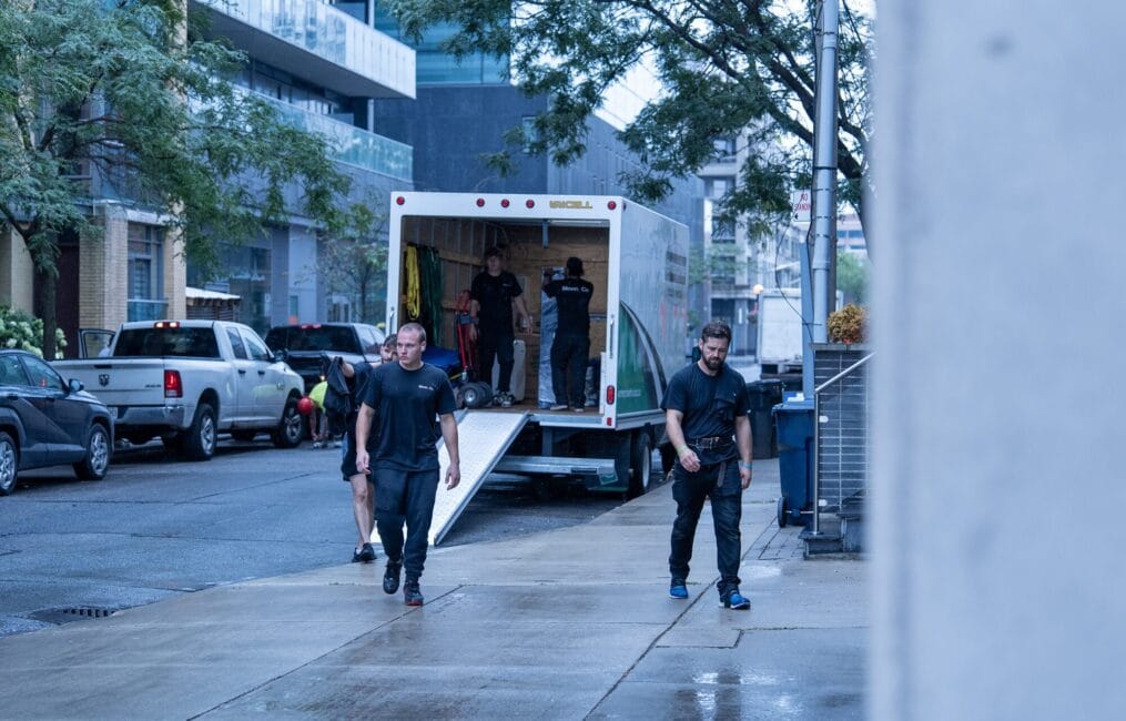 Moving Co. movers walking back to the truck on a downtown Toronto street