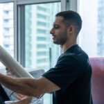 Moving Co. mover holding a roll of shrink wrap in a condo