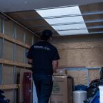 Moving Co. mover loading boxes into the back of the moving truck