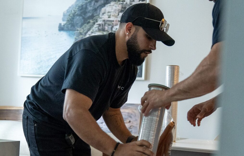 Moving Co. mover wrapping a chair in plastic in a condo
