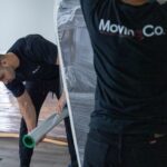 Moving Co. movers shrink-wrapping furniture on the floor of a condo