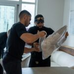Three Moving Co. movers wrapping a chair in plastic