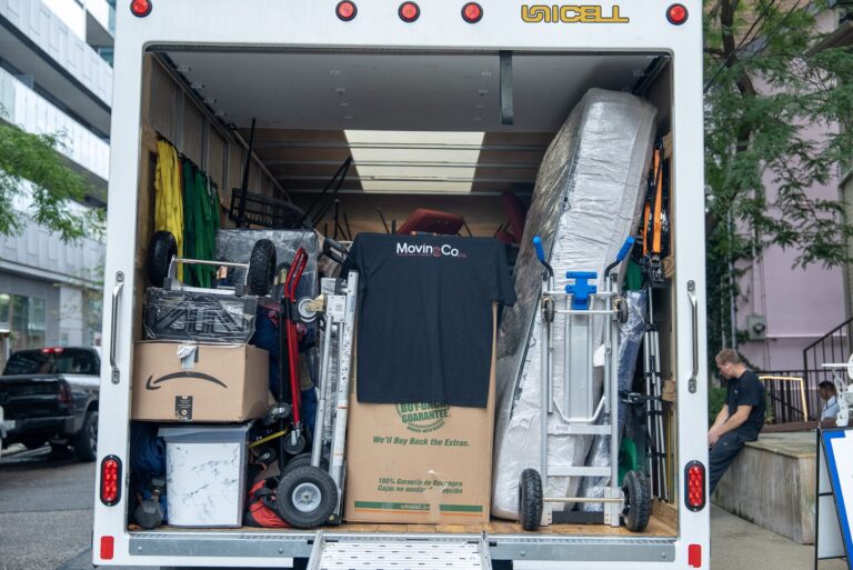 Back of the Moving Co. truck, loaded with boxes, dollies and a mattress