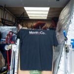 Inside the Moving Co. truck, with dollies, boxes and a Moving Co. shirt hanging up