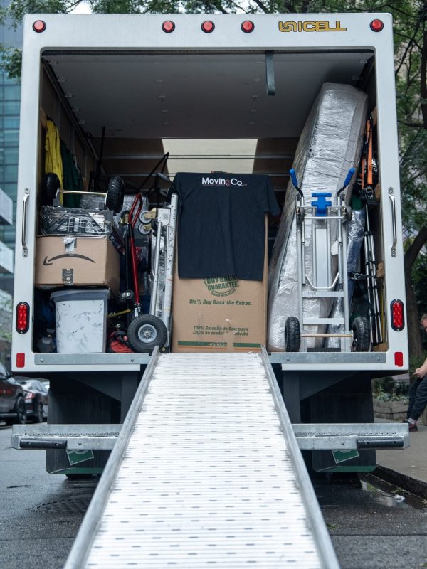 Moving Co. truck with the ramp down, dollies and moving blankets ready